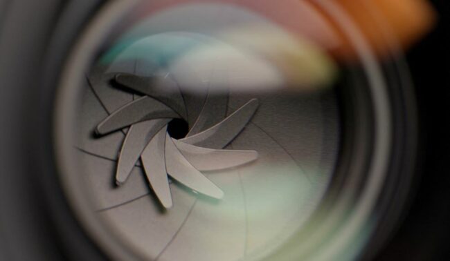 Close up of camera aperture displaying overlapping blades. 