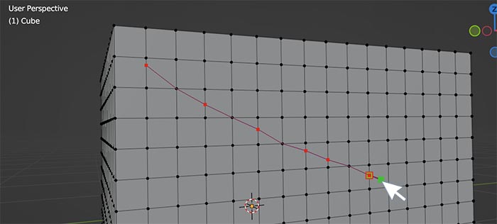 The knife tool is used to cut a red diagonal line across the mesh of a cube in Blender. 